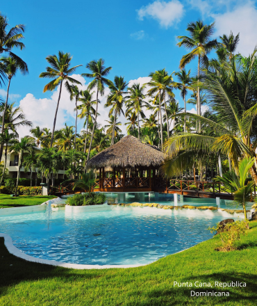 Relájate junto a la piscina turquesa entre exuberantes palmeras en el resort tropical de Punta Cana.
